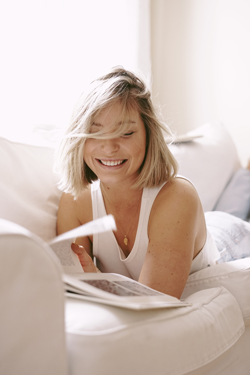 Woman in White Tank Top Sitting on Bed